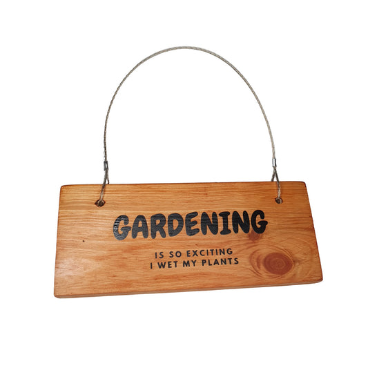 "gardening is so exciting i wet my plants" black vinyl text on varnished natural wooden plaque with pvc coated metal hanging loop